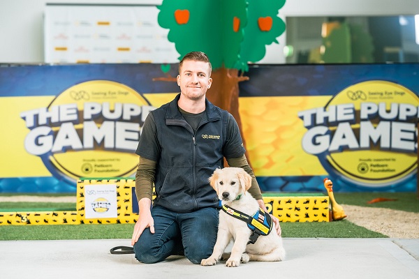 Trainer Jack sits with Golden Retriever puppy athlete, Tambo